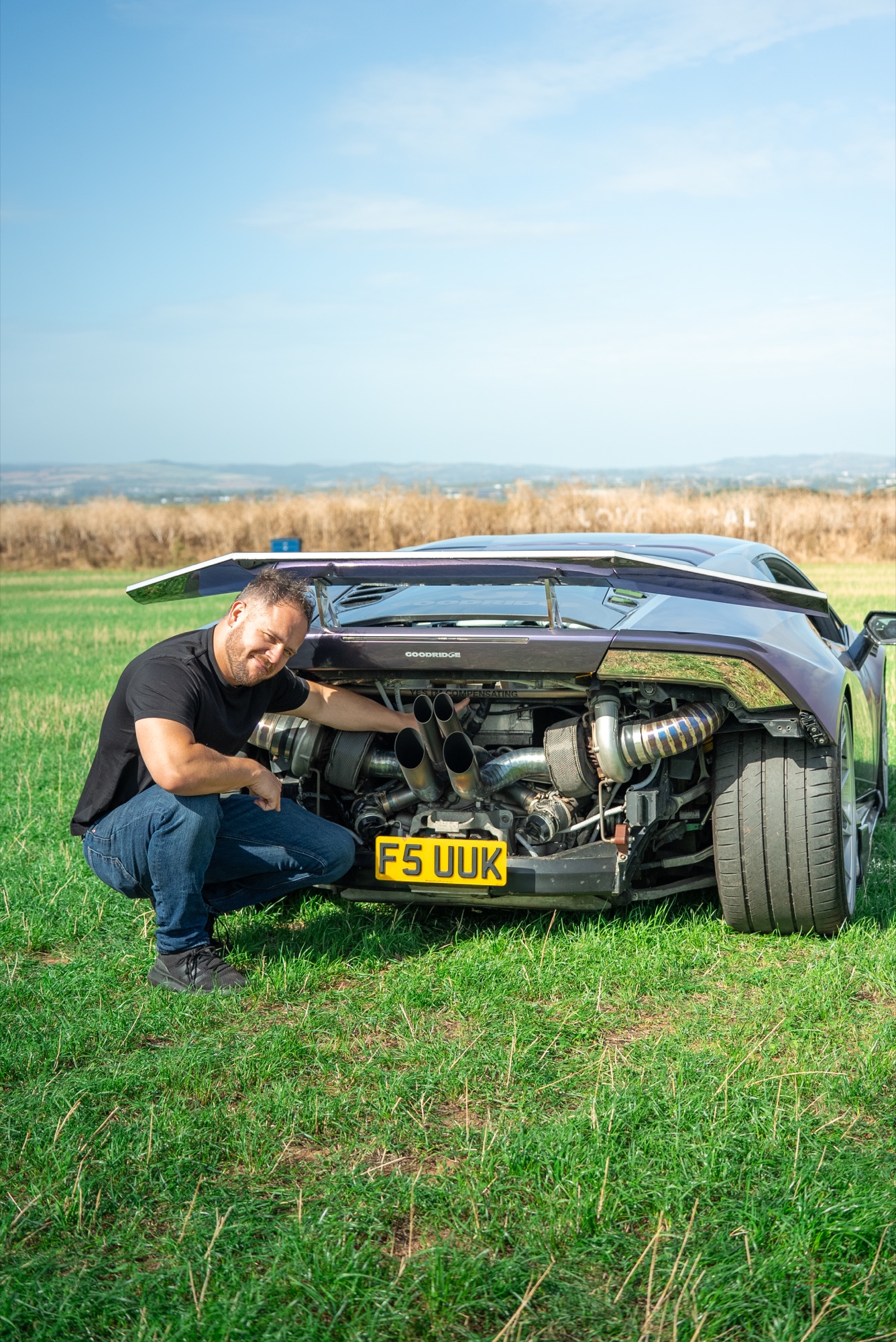 Corey England pointing out the twin-turbo setup on his Huracán