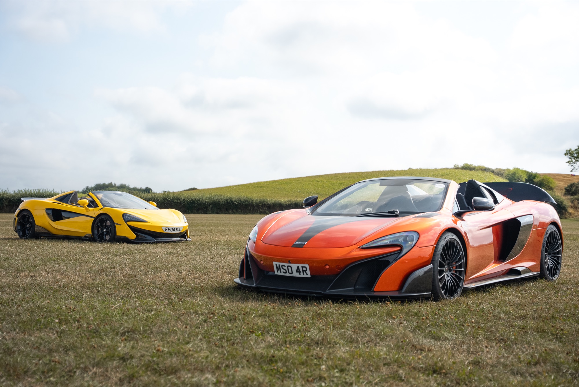 Orange McLaren 650S and yellow 570S in a field — Payn Media shop