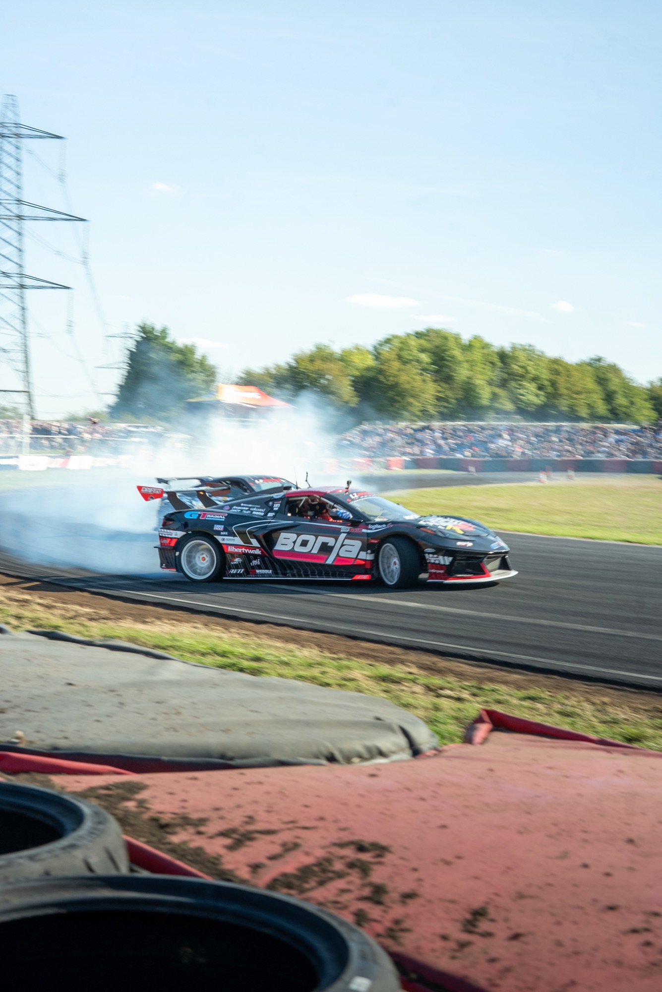 Black Corvette on opposite lock at LZ World Tour, Borla livery and tyre smoke