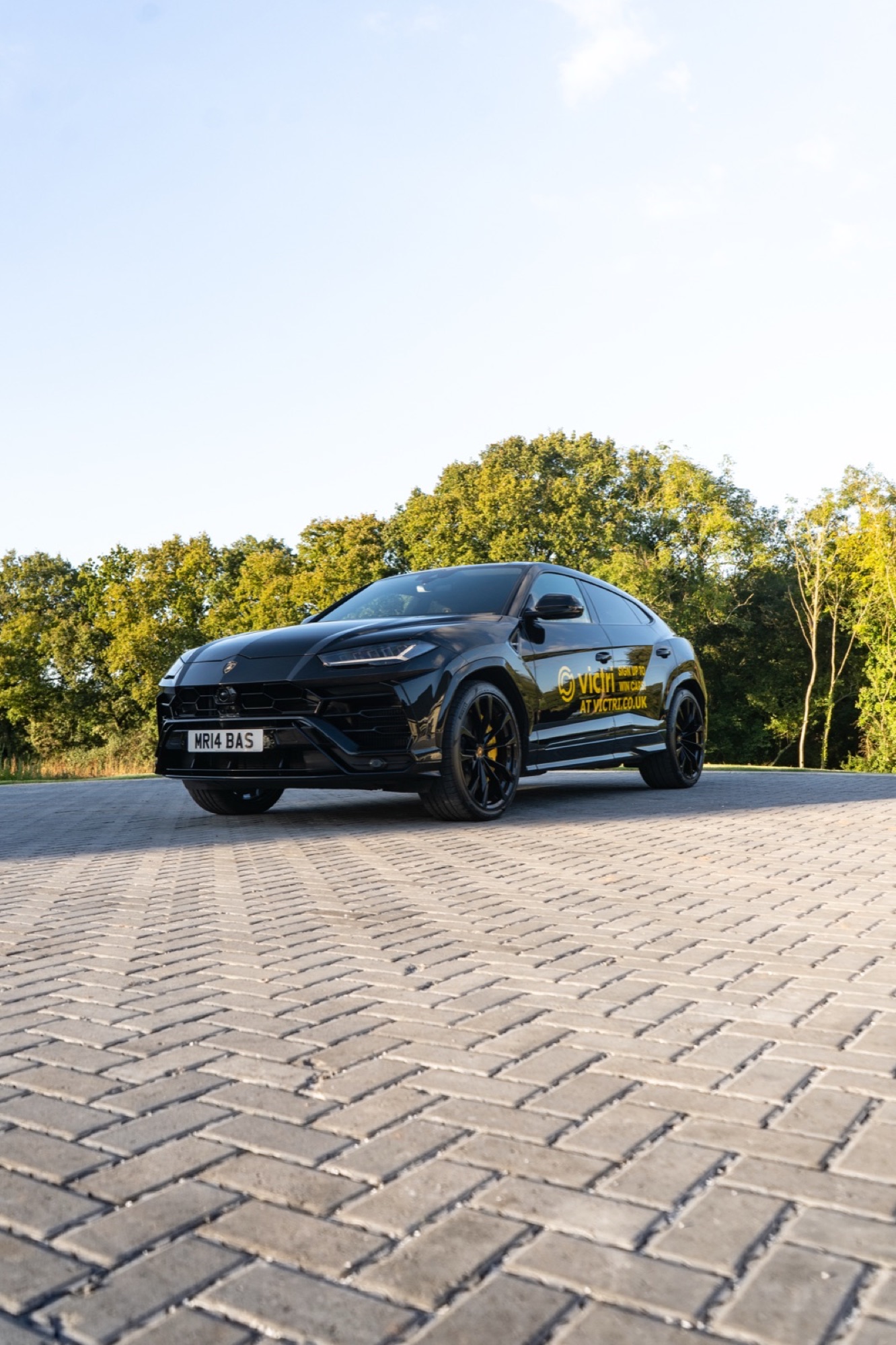 Black Lamborghini Urus on brick, evening light
