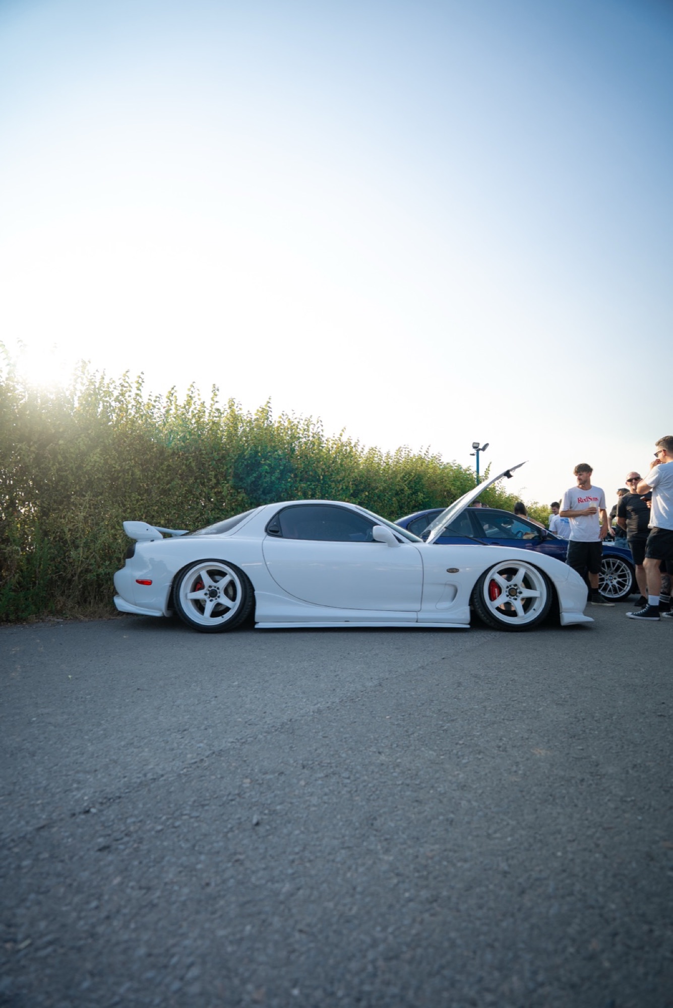 White Mazda RX-7 FD with the hood up at a meet