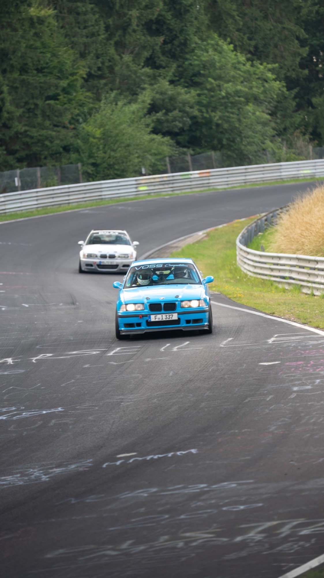 Blue BMW E36 on the Nordschleife, graffiti on the tarmac