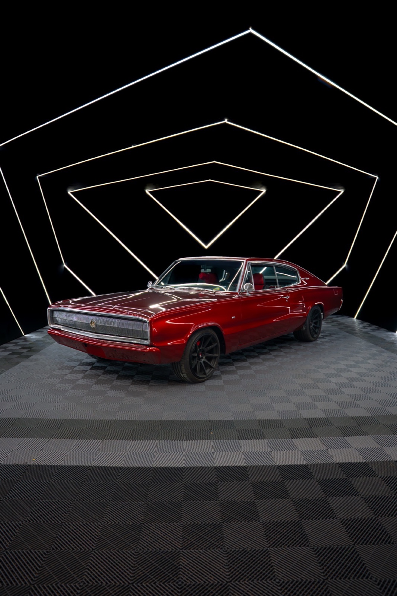 Red Dodge Charger in a black studio with LED triangles